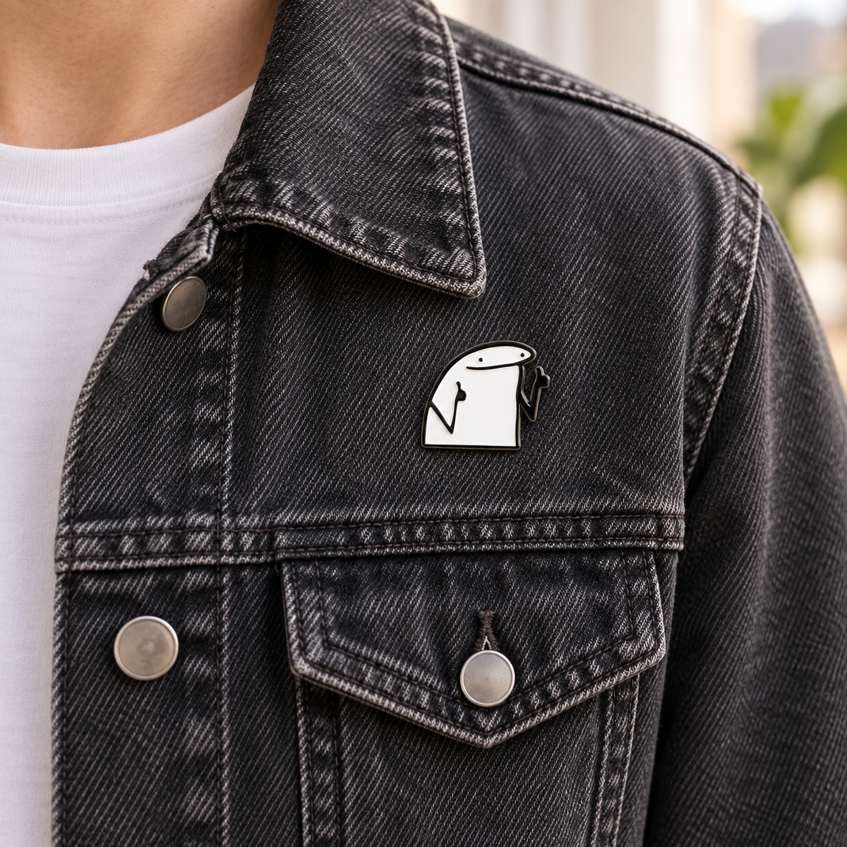AI-styled wearing view of Cheeky Double Gesture Character Pin on dark washed denim jacket being worn by an adult over a plain white shirt. Pin at upper chest