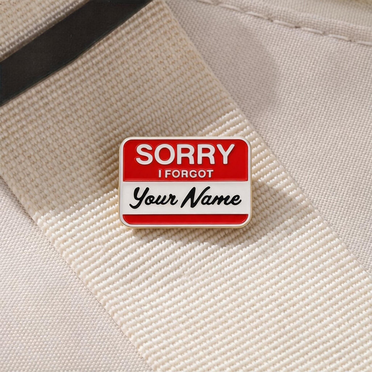 Sorry I Forgot Your Name Enamel Pin worn on a cream canvas bag