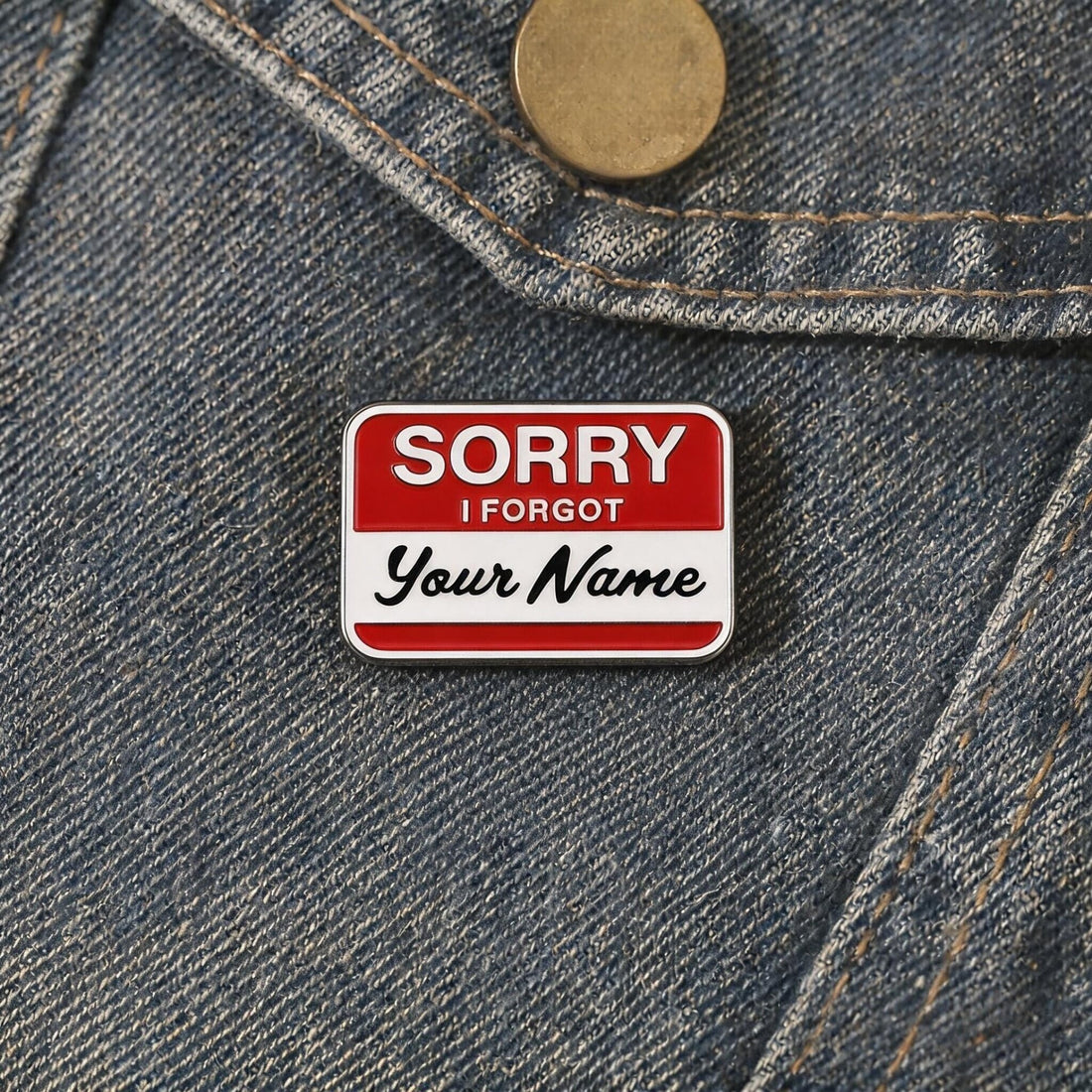 Red-and-white Sorry I Forgot Your Name enamel pin on a soft pale yellow background