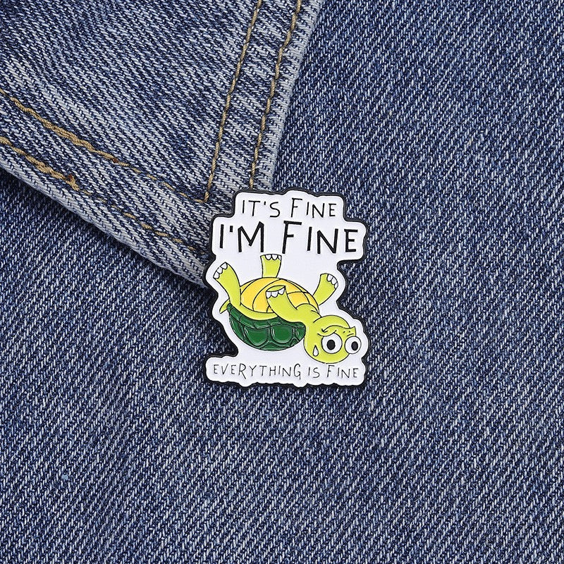 It's Fine, I'm Fine Upside-Down Turtle Enamel Pin worn on denim