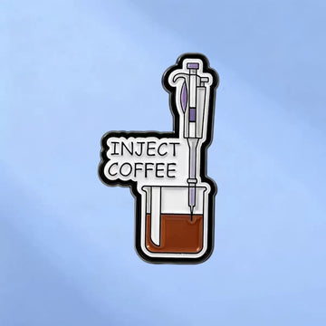 Inject Coffee enamel pin showing a purple-accented syringe above a coffee-filled beaker on blue
