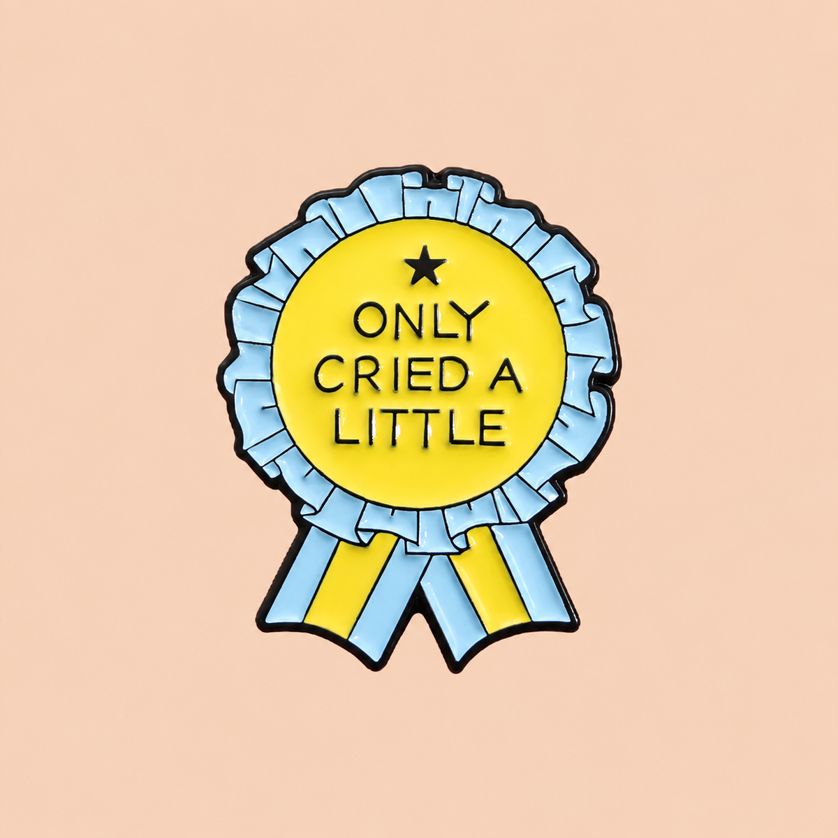 Yellow and light blue Only Cried a Little rosette enamel pin on a warm peach background