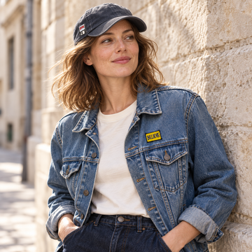 Doom enamel pin on a vintage cap and yellow BELIEVE pin on a denim jacket